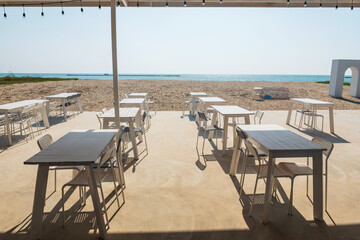 Coffee cafes outdoor tables and chairs by beach in summer