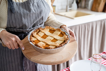 closeup of a woman hands holding pumpkin pie at home kitchen