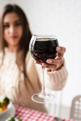 woman having thanksgiving dinner at home kitchen celebrating holiday, holding wine glass