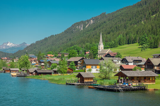 Beautiful shores of weissensee lake in Austria, beautiful backdrop with alpine lake in the heat of the summer. Wide panorama taken from the bridge in the middle.