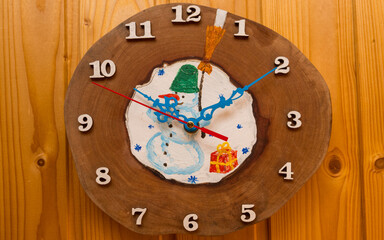 Wall clocks, fireplace clocks are handmade. I drew a snowman and New Year's gifts on the cut of a pear tree. New Year's drawing on a tree cut.