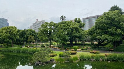 Fototapeta na wymiar The zen garden and the city skyscrapers view at the Hibiya park Tokyo central downtown, next to the Imperial palace, year 2022 June 11th