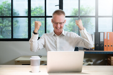 Businessman feeling euphoric celebrating online win success achievement result, young man happy about good email news, motivated by great offer or new opportunity