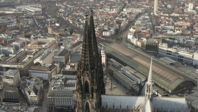 Aerial descending shot of tall tower of gothic Cologne Cathedral. Tilt up reveal panoramic view of large city. Cologne, Germany