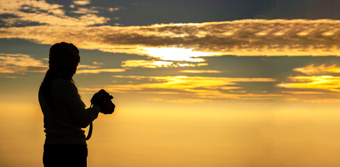 Fototapeta premium Silhouette Asian woman Nature photographer,Beautiful background at sunset