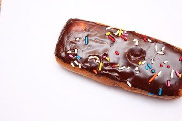 Chocolate donut bar topped with multicolored sugar flakes. laid on a white background