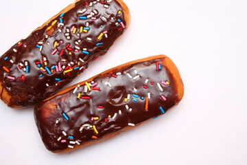 Chocolate donut bar topped with multicolored sugar flakes. laid on a white background