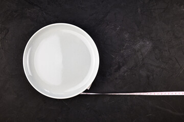 a plate wrapped with a centimeter on a black background with a copy space concept dietary nutrition
