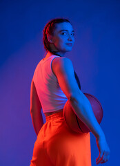 sports girl in the studio in shorts, a T-shirt with a basketball. blue background. sport concept. sports, healthy lifestyle
