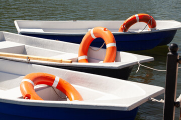 Pier with lifebuoy and boat. Boats for walking. Boats rental. Relax in the summer