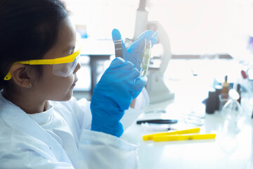 Asian little girl student with magnifying glass learning research science class