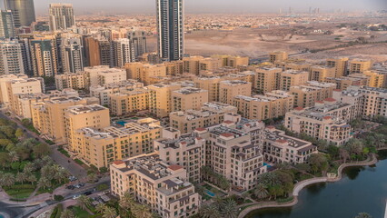 Low rise buildings in Greens district and skyscrapers in Barsha Heights district aerial timelapse. Dubai skyline