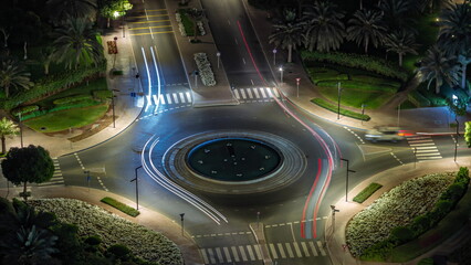 Traffic on a road intersection with roundabout in Greens district aerial night timelapse.