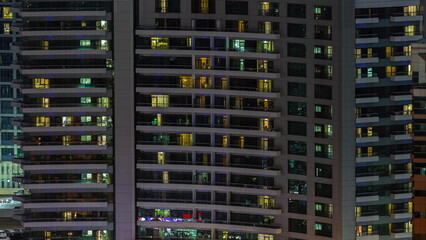 Windows of apartment building at night timelapse, the light from illuminated rooms of houses