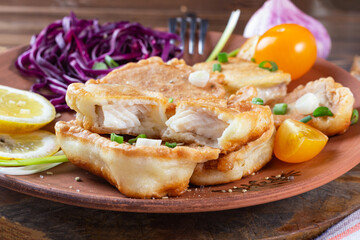 pieces of tilapia fish in cheese batter lightly fried in olive oil. appetizing, tasty healthy food.