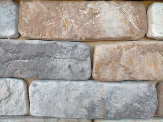 Stone wall background, smooth rectangular stones. white, gray and beige.