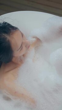 the young  black long hair woman Bubble bath in the bathtub