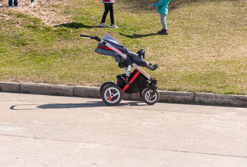 an empty baby carriage at the edge of the road . the concept of the loss or theft of a child,