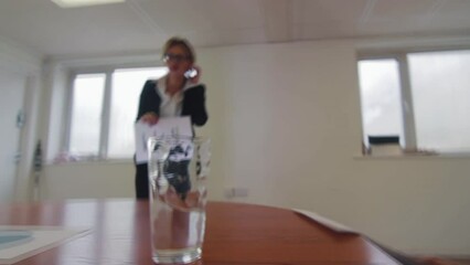 An earthquake shakes an office with water on a table at a business meeting presentation