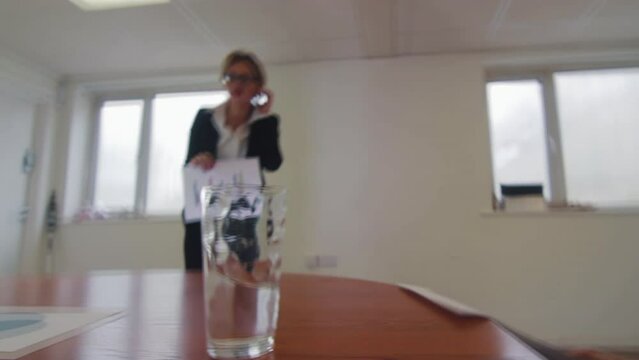 An earthquake shakes an office with water on a table at a business meeting presentation