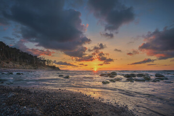Fototapeta na wymiar Colorful sunset on the sea rocky shore