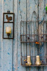Wrought iron decorations hung on a natural wood panel with the trace of fibers and chips of blue flaked paint symbol of Provence
