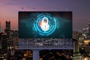 Padlock icon hologram on road billboard over panorama city view of Bangkok at night to protect business, Southeast Asia. The concept of information security shields.