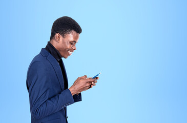 African businessman using mobile phone, laughing on blue backgro