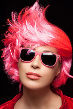 Fashion model girl with stylish glossy pink wig. Hairstyle and fashion wigs concept.