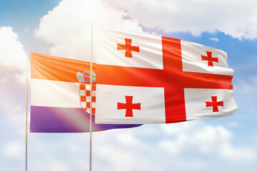 Sunny blue sky and flags of georgia and croatia