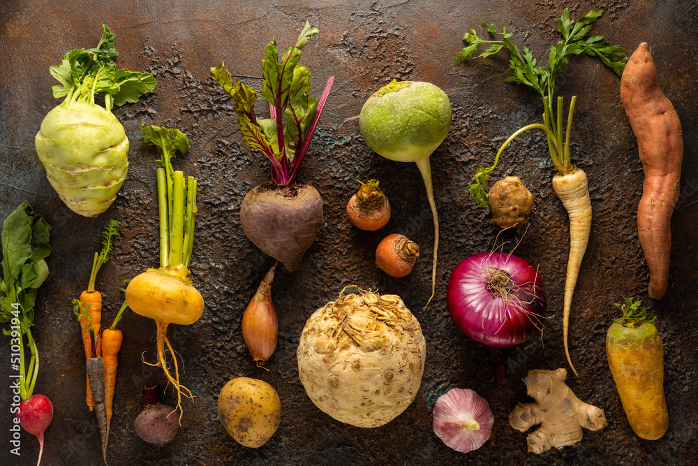 Wall mural Assortment of Vegetables and root vegetables on textured background. Autumn harvest. Healthy food and vegetarian concept.