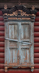 A window with wooden carved sashes. Wooden architecture