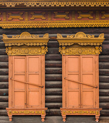 A window with wooden carved sashes. Wooden architecture
