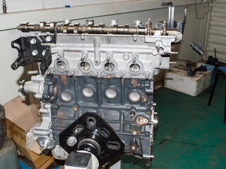 View from the side of the exhaust manifold mounting on a partially disassembled automobile engine mounted on an engine repair stand