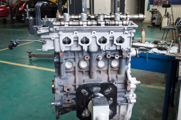 View from the side of the intake manifold mounting on a partially disassembled car engine mounted on an engine repair stand