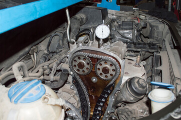 Checking the engine installed on the car using the indicator head. The timing chain drive is visible
