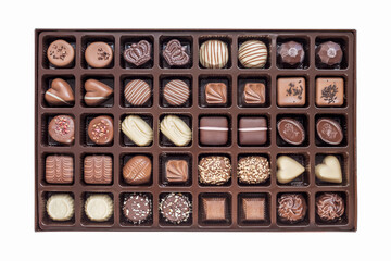 a set of festive chocolate sweets of various shapes and designs in a box isolated on a white background. view from above. top view