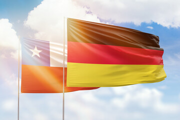 Sunny blue sky and flags of germany and chile