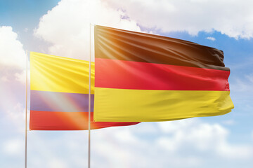 Sunny blue sky and flags of germany and colombia