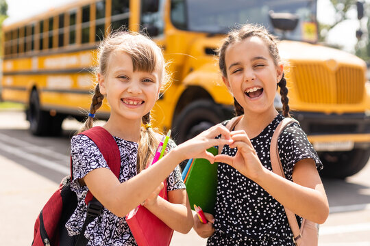 Education: Smiling Student Friends Ready For School next to school bus