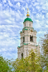 The ancient bell tower of the church on the background of a blue sky with clouds. 3