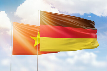 Sunny blue sky and flags of germany and vietnam
