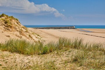 Fototapeta na wymiar Image of Carteret Plage with sand dunes and the harbour wall