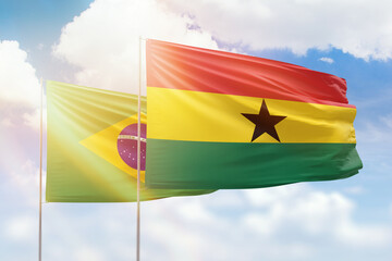 Sunny blue sky and flags of ghana and brazil