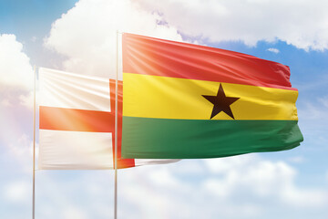 Sunny blue sky and flags of ghana and england