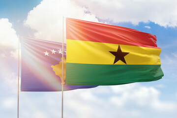 Sunny blue sky and flags of ghana and kosovo