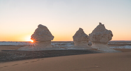 Sunset in the white desert in Egypt, with amazing white rock formations and the sun setting © Simona