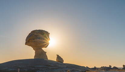 Sunset in the white desert in Egypt, with amazing white rock formations and the sun setting