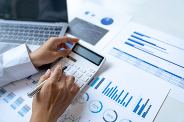 Close up Businessman using calculator and laptop for calculating finance, tax, accounting, statistics and analytic research concept