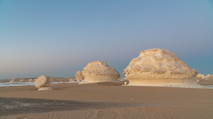 Sunset in the white desert in Egypt, with amazing white rock formations and the sun setting © Simona